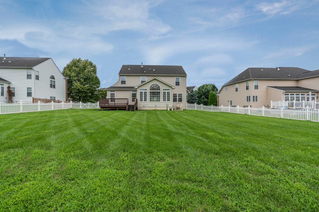 A beautiful suburban home with a big green backyard.