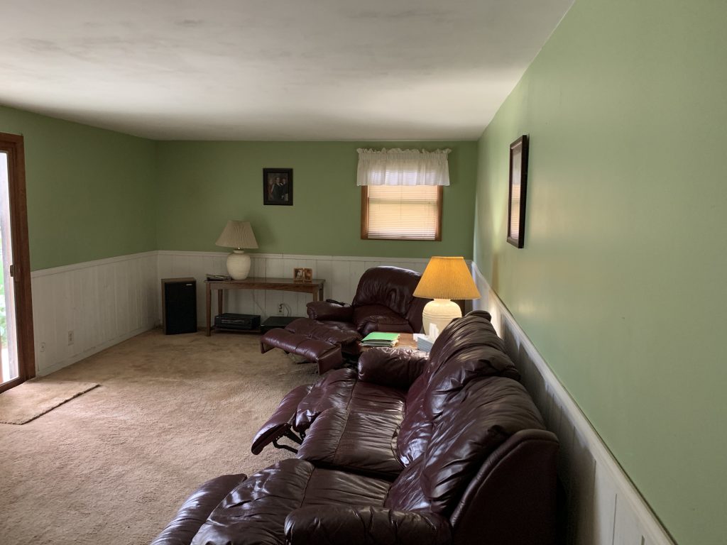 A lounge area of a home featuring lime green walls and leather recliners.