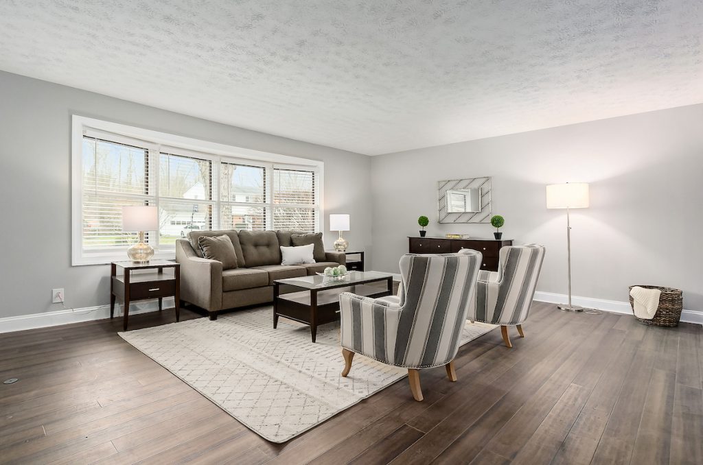 A lovely living room with modern chairs, flooring, and a rug.