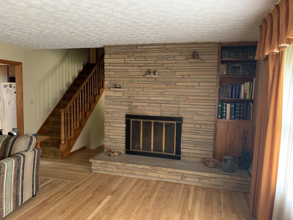 A living room hearth and wooden staircase.