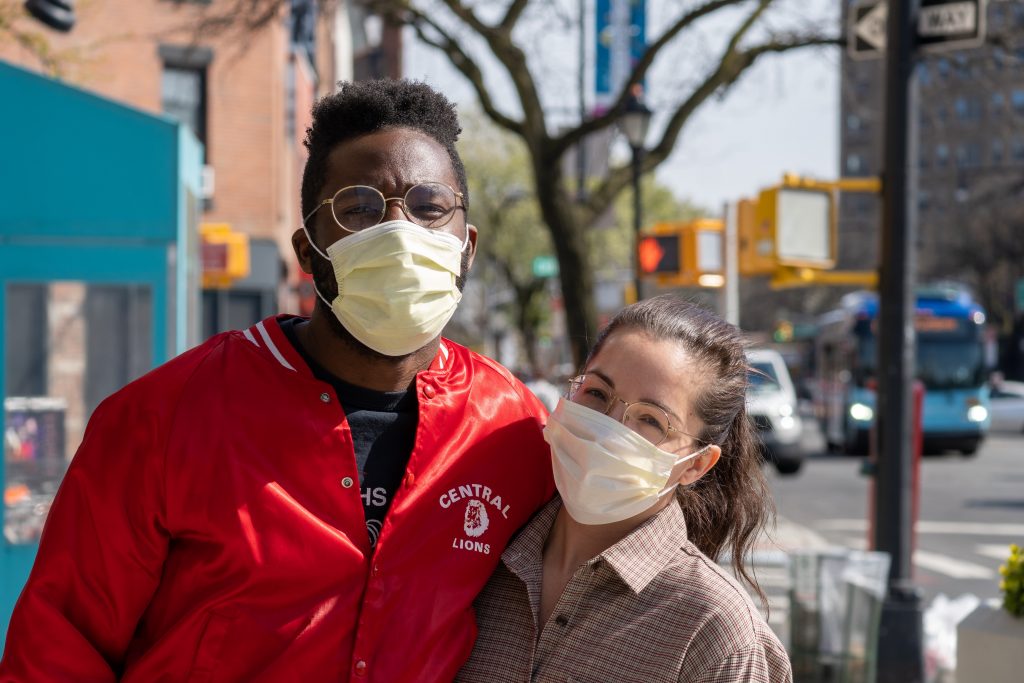 A couple with masks pose for a picture before moving out of the city during COVID.