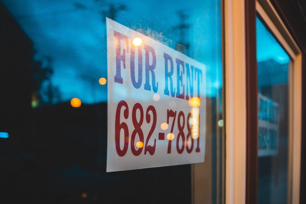 "For Rent" sign in a window with a number to call.