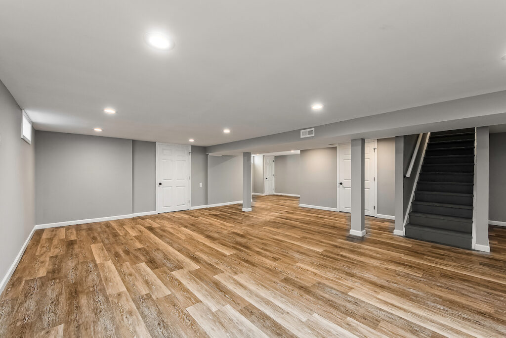 A recently remodeled basement with natural wood tiling.