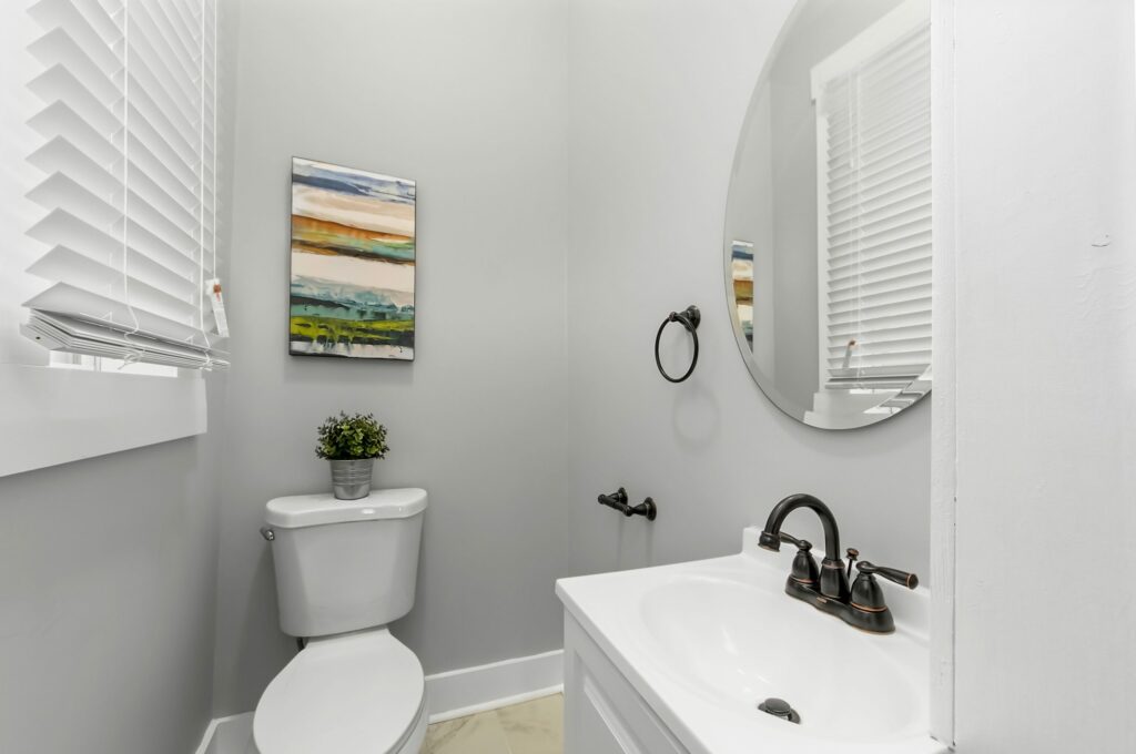 Circular mirror by a toilet.