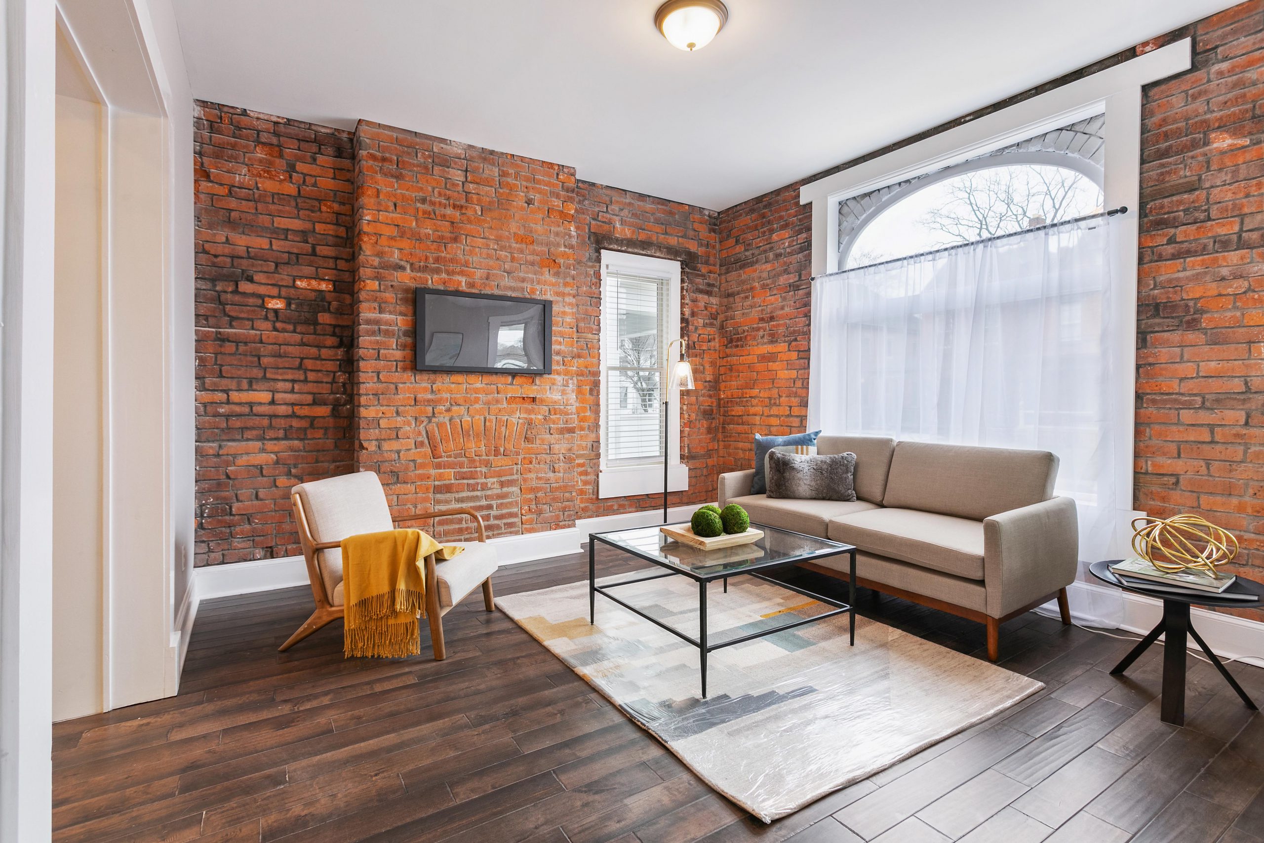 A modern living room with tons exposed brick.