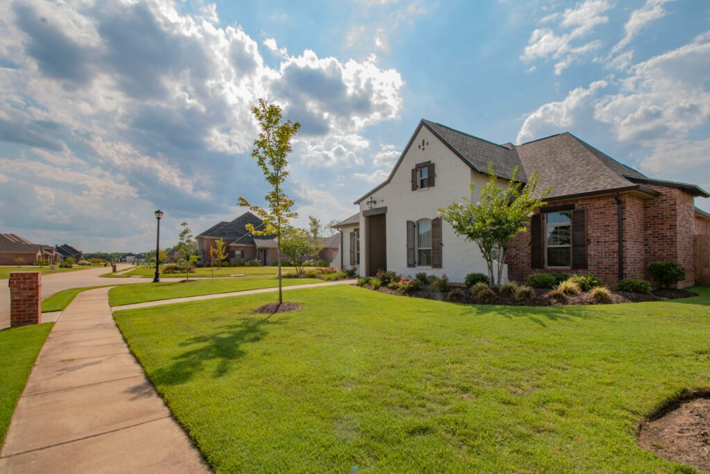 A nice suburban home with a sidewalk and a green lawn.