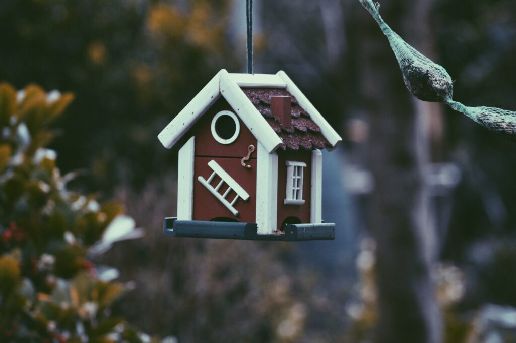 A tiny birdhouse hanging — proof that not everything sells in a hot house market. 