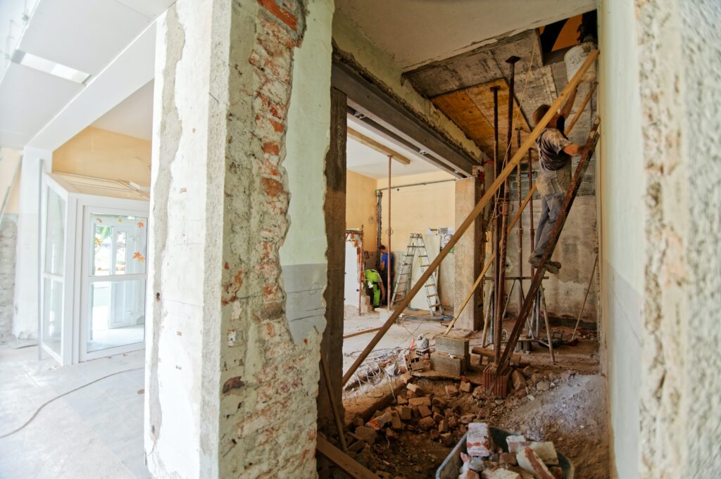 A man working on a ladder inside a condemned property.