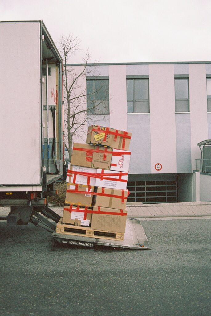 A large stack of boxes being loaded onto a moving truck to save on moving costs.