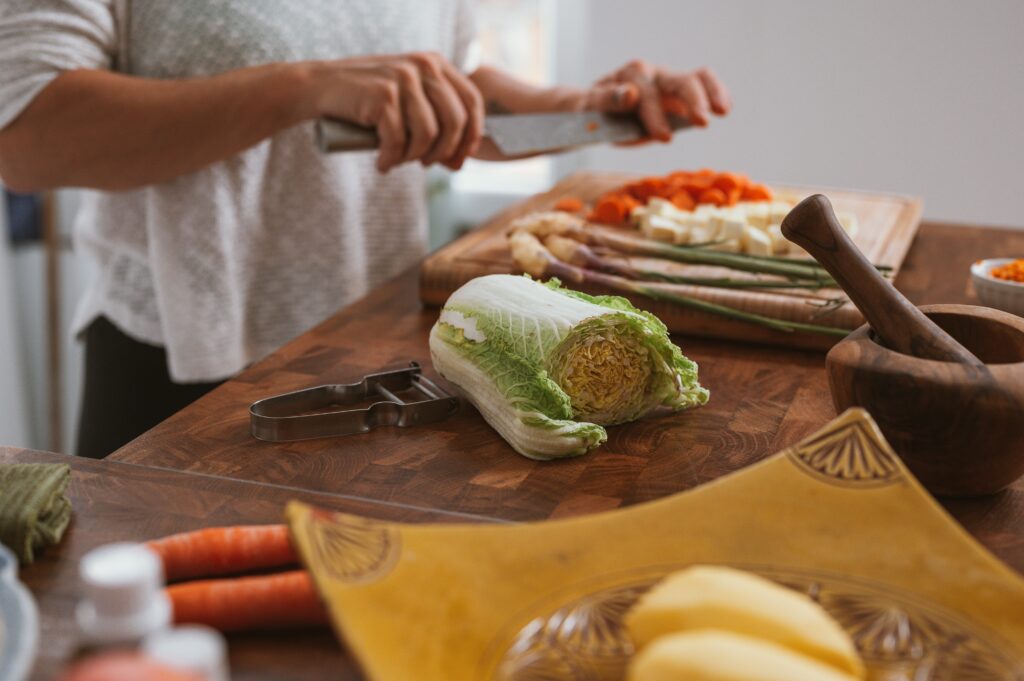 A chef cutting vegetables on a kitchen counter.