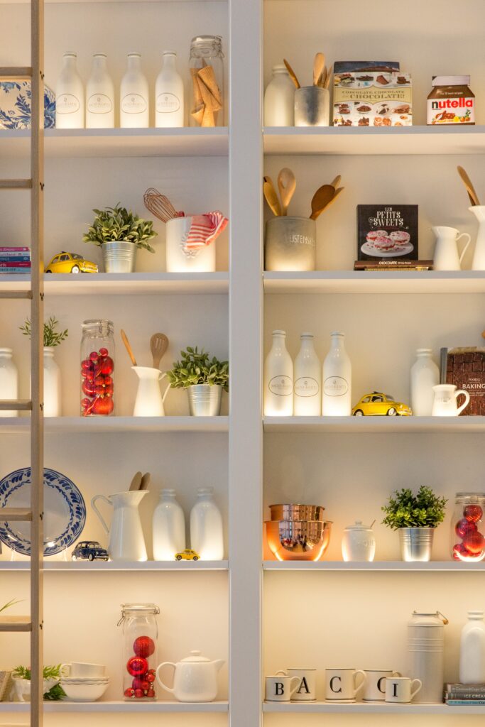 Various cooking items and ingredients organized on shelves in a messy kitchen.